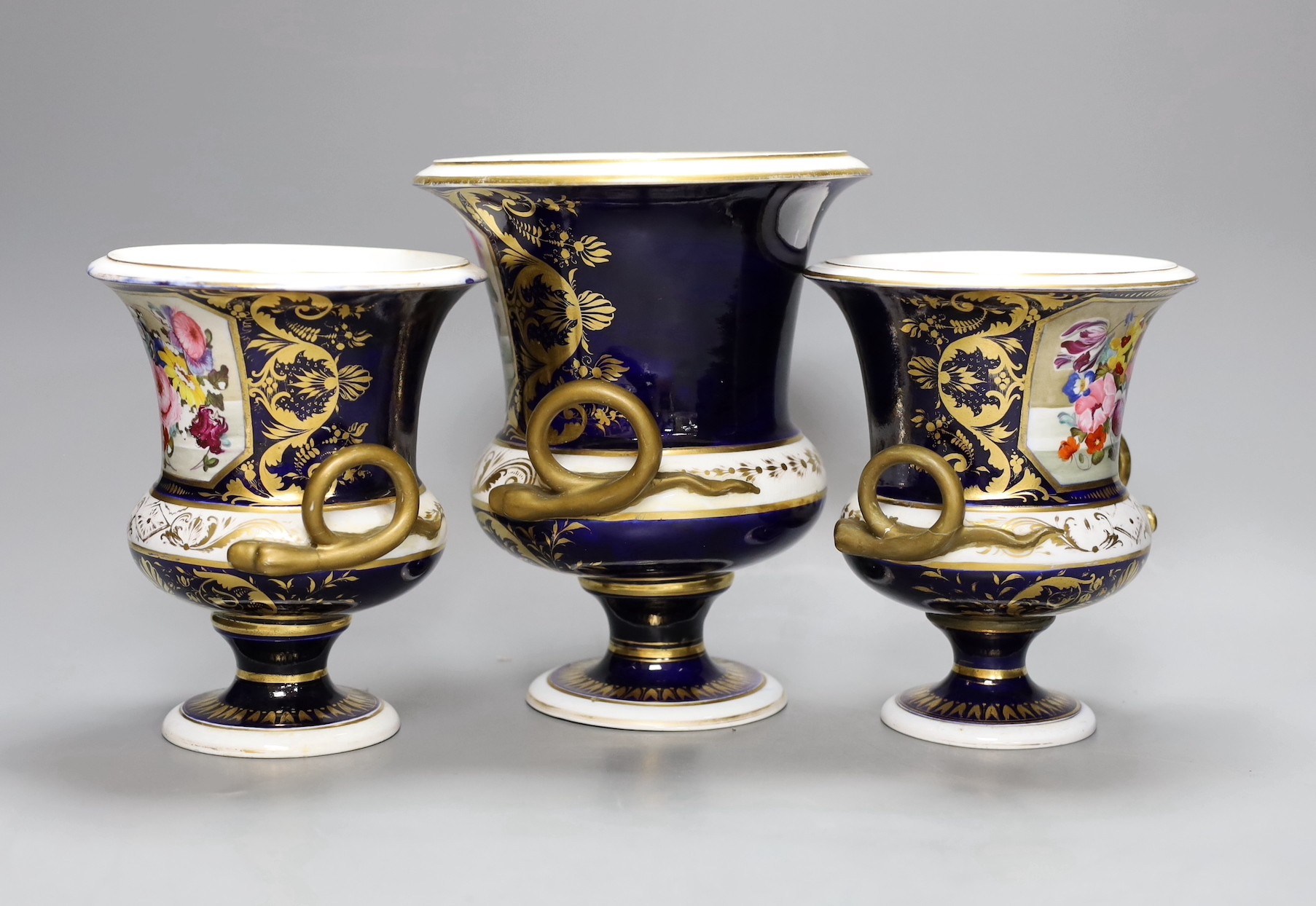 A garniture of three early 19th century floral painted Derby vases, tallest 20cm